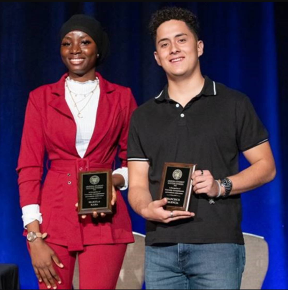 Makula Kaba and Francisco Valencia accept their awards at the Office of English Language Acquisition Services conference on December 9, 2022.