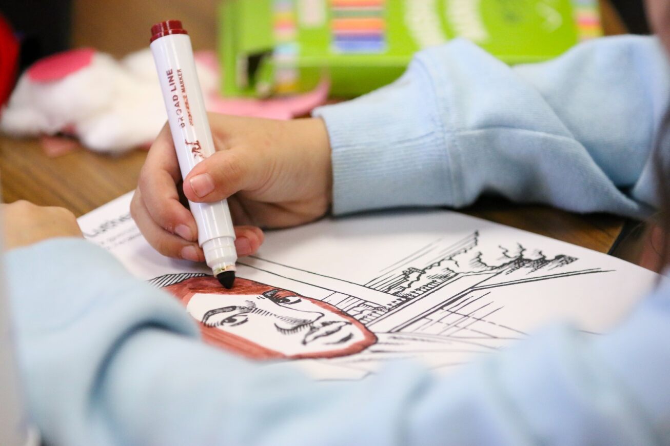 A student colors an MLK Jr. coloring page.
